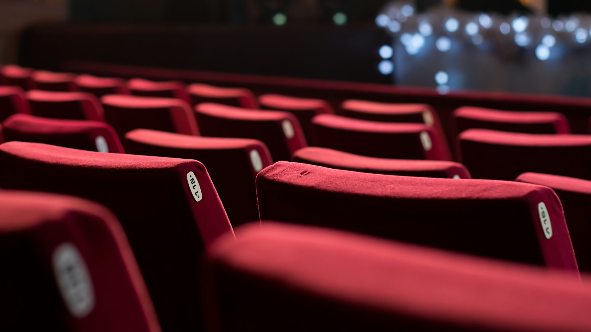 a row of red seats in a theater spectrautonomie.be